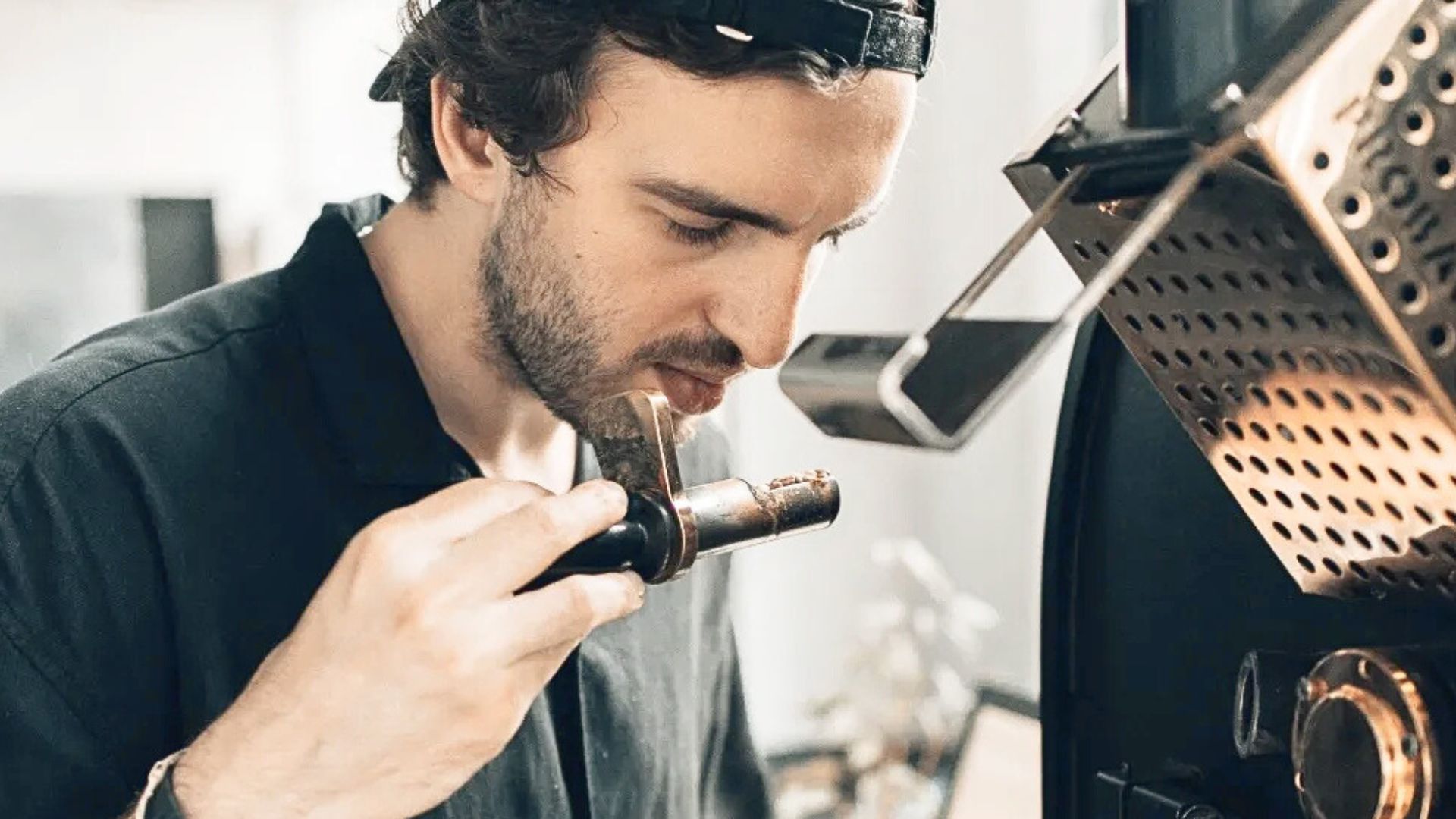 Coffee roaster assessing aroma during roasting to maintain consistency across multiple origins and green coffee lots