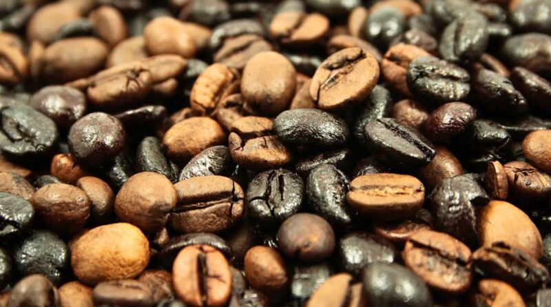 Coffee beans showing uneven roast levels, including scorched and underdeveloped beans caused by roast defects