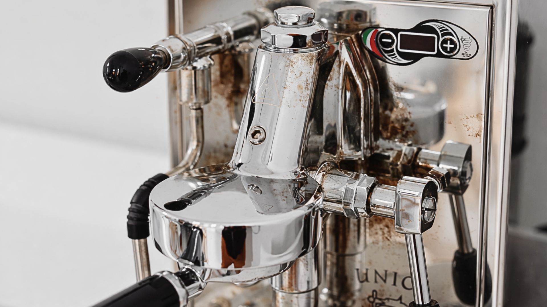Close-up of coffee oil residue buildup on internal espresso machine components that require regular cleaning to prevent off-flavors