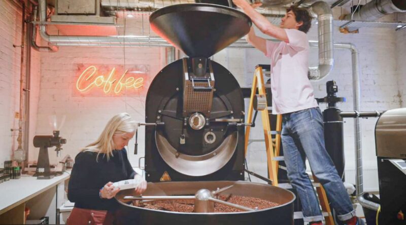 Coffee roastery team operating a commercial roasting machine, illustrating the shift from craft roasting to scalable production systems