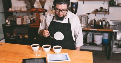 “Coffee professional cupping and evaluating coffee quality as part of sourcing decisions between certified coffee and direct trade.”
