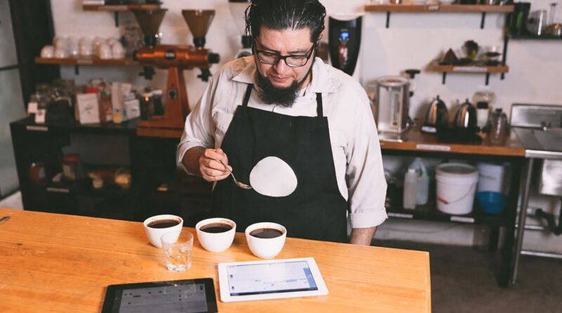 “Coffee professional cupping and evaluating coffee quality as part of sourcing decisions between certified coffee and direct trade.”